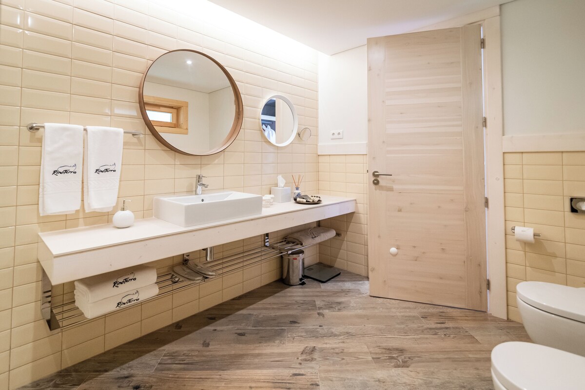 A modern bathroom with a white sink, two mirrors, and a toilet.