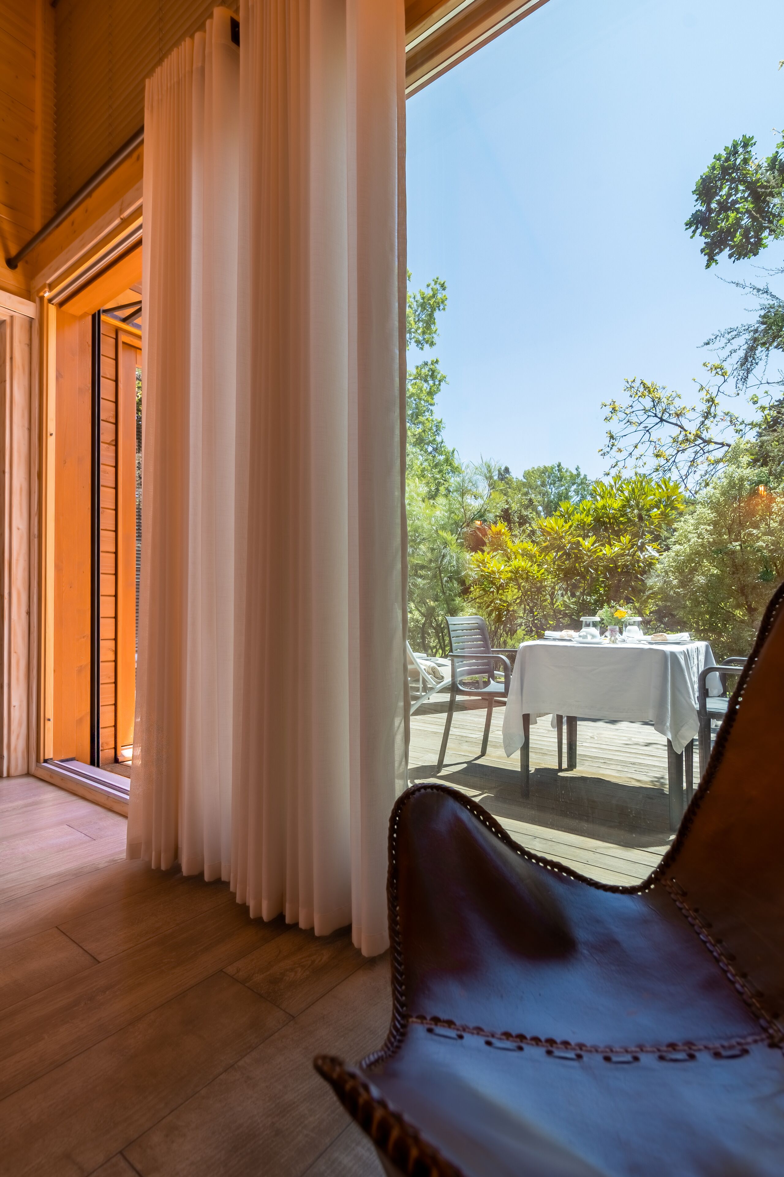 A wooden interior with a view of an outdoor dining area.