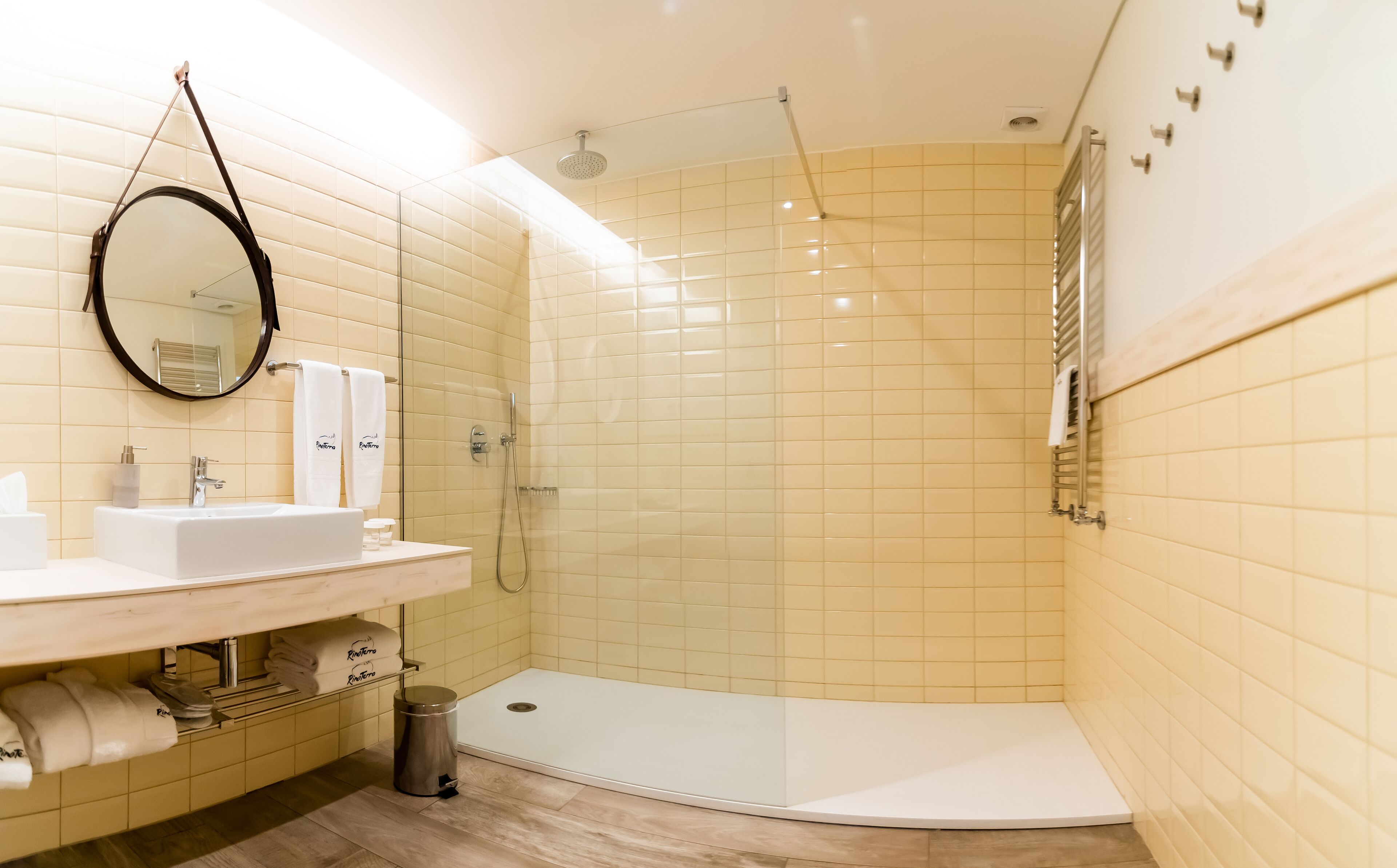 Un baño moderno con lavamanos, espejo y ducha.