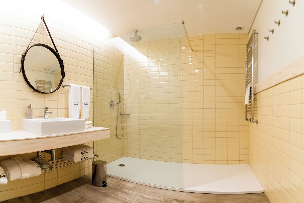 A modern bathroom with a sink, mirror, and shower.