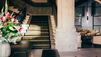 Eine imposante Treppe mit modernem Design, die zu einer Sitzecke mit bequemen Sofas führt.