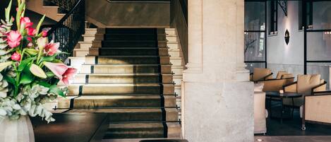 A grand staircase with a modern design, leading to a seating area with comfortable sofas.