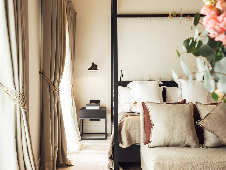Un dormitorio con una cama con dosel, una mesita de noche y una mesilla.