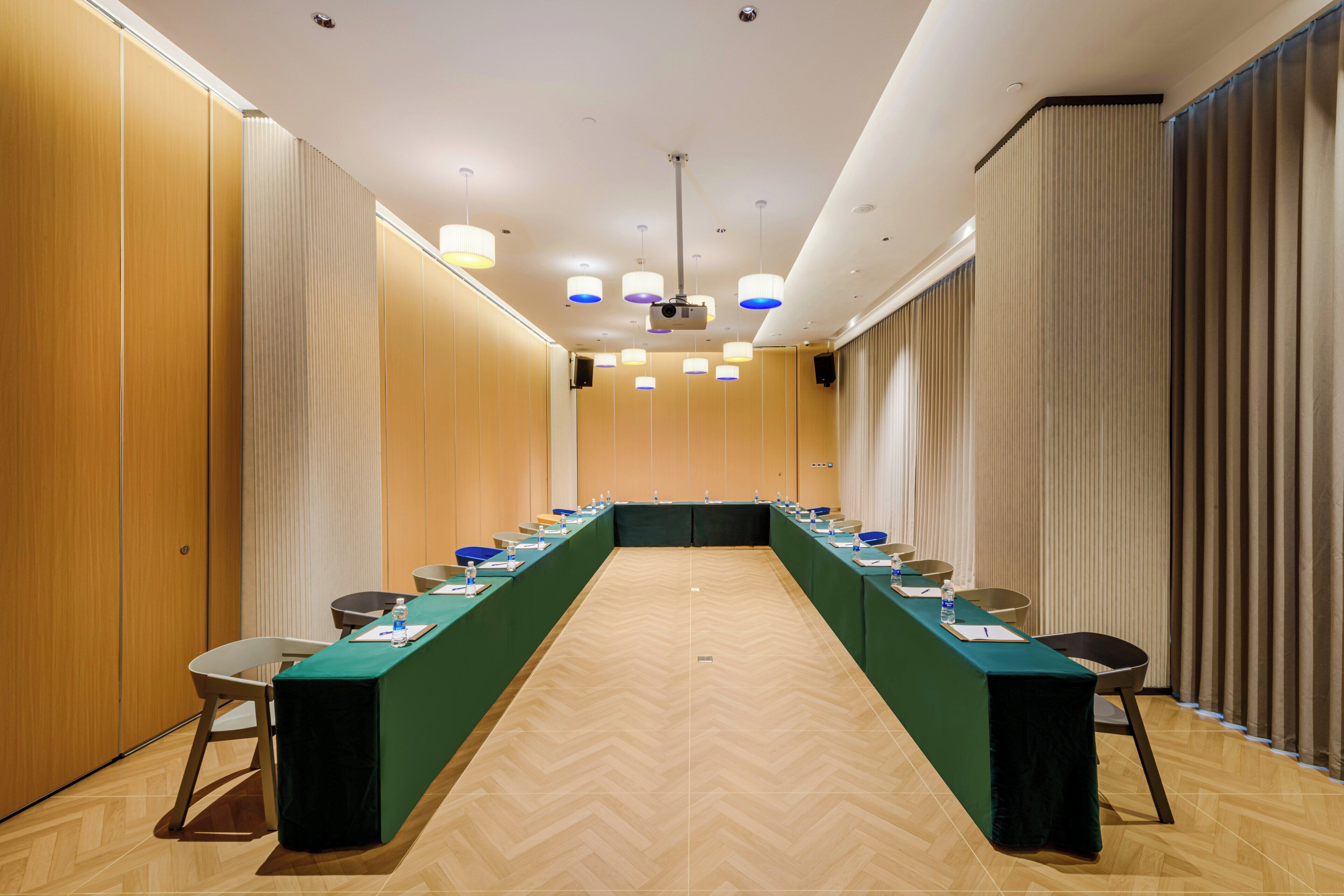 A conference room with a long table, chairs, and a projector.