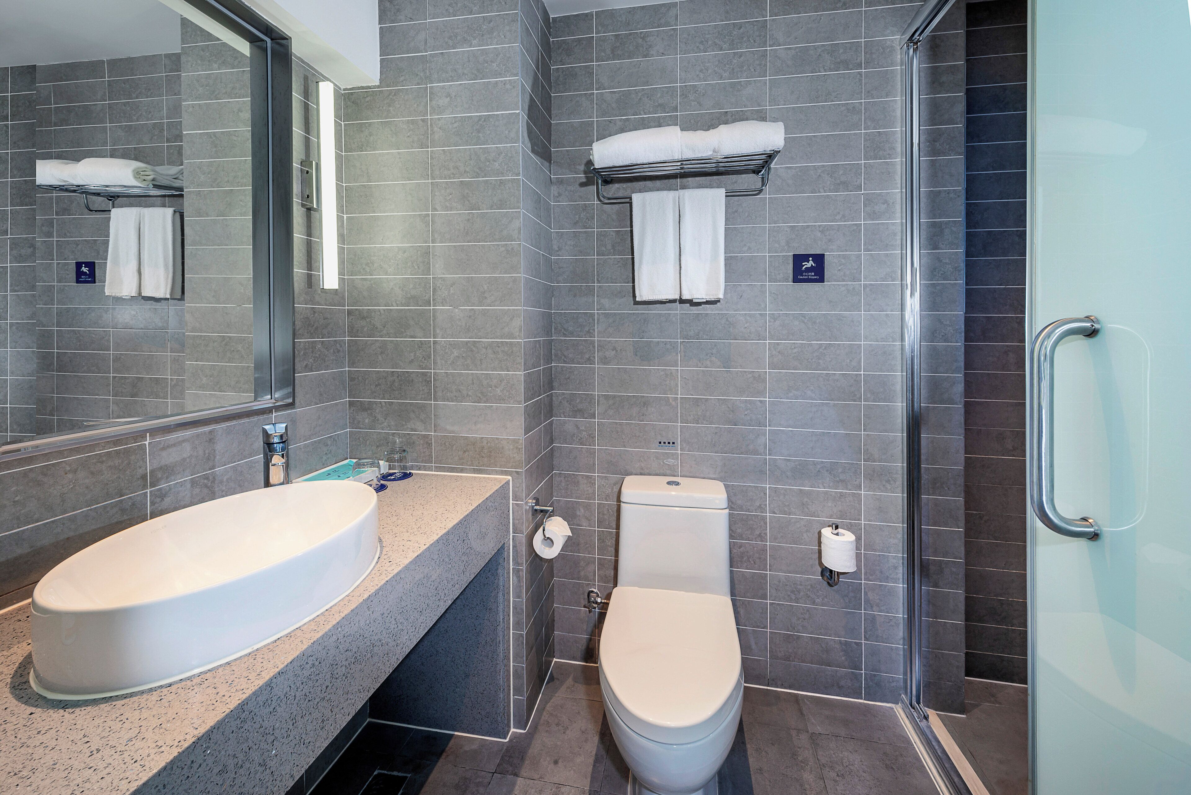 Un bagno moderno con doppio lavandino, toilette e cabina doccia in vetro.