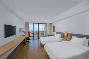 A hotel room with two beds, a desk, a TV, and a balcony with a view. - Holiday Inn Express Haikou West Coast by IHG (Haikou)