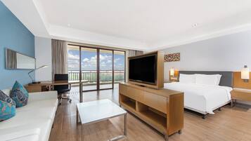 A hotel room with a bed, a TV, a desk, and a balcony with a view.