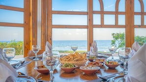 A table set for a meal with a view of the ocean through large windows. - Three Corners Equinox Beach Resort (Marsa Alam)