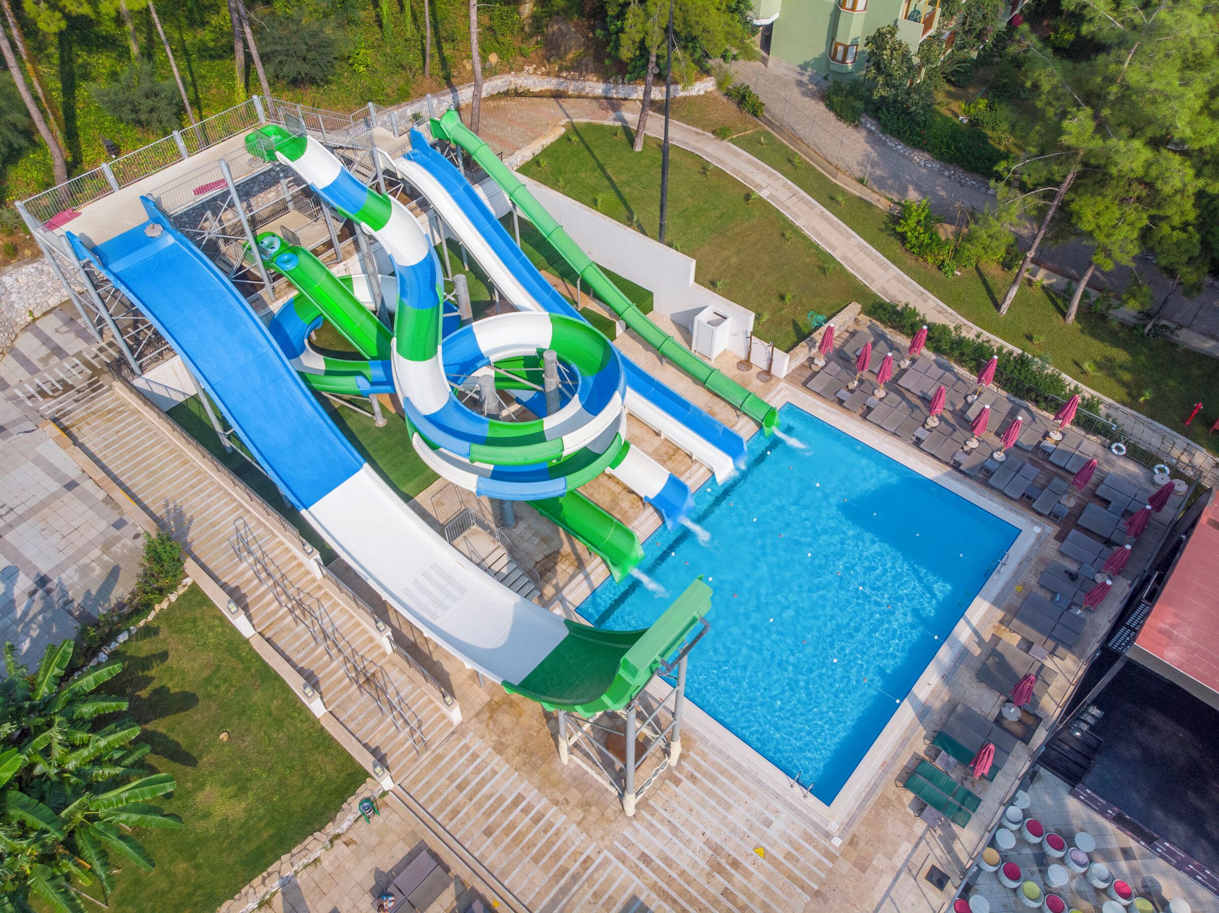 Parque acuático con múltiples toboganes y una piscina.