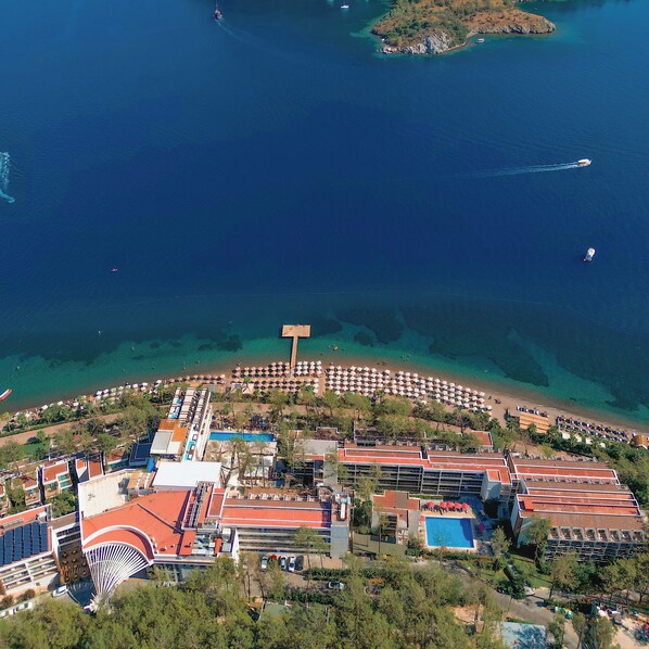 An aerial view of a coastal resort with a beach, pool, and multiple buildings. - Orka Lotus Beach (Marmaris)