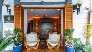 A wooden porch with two rocking chairs, a small table, and potted plants. - Akkan Hotel (Bodrum)