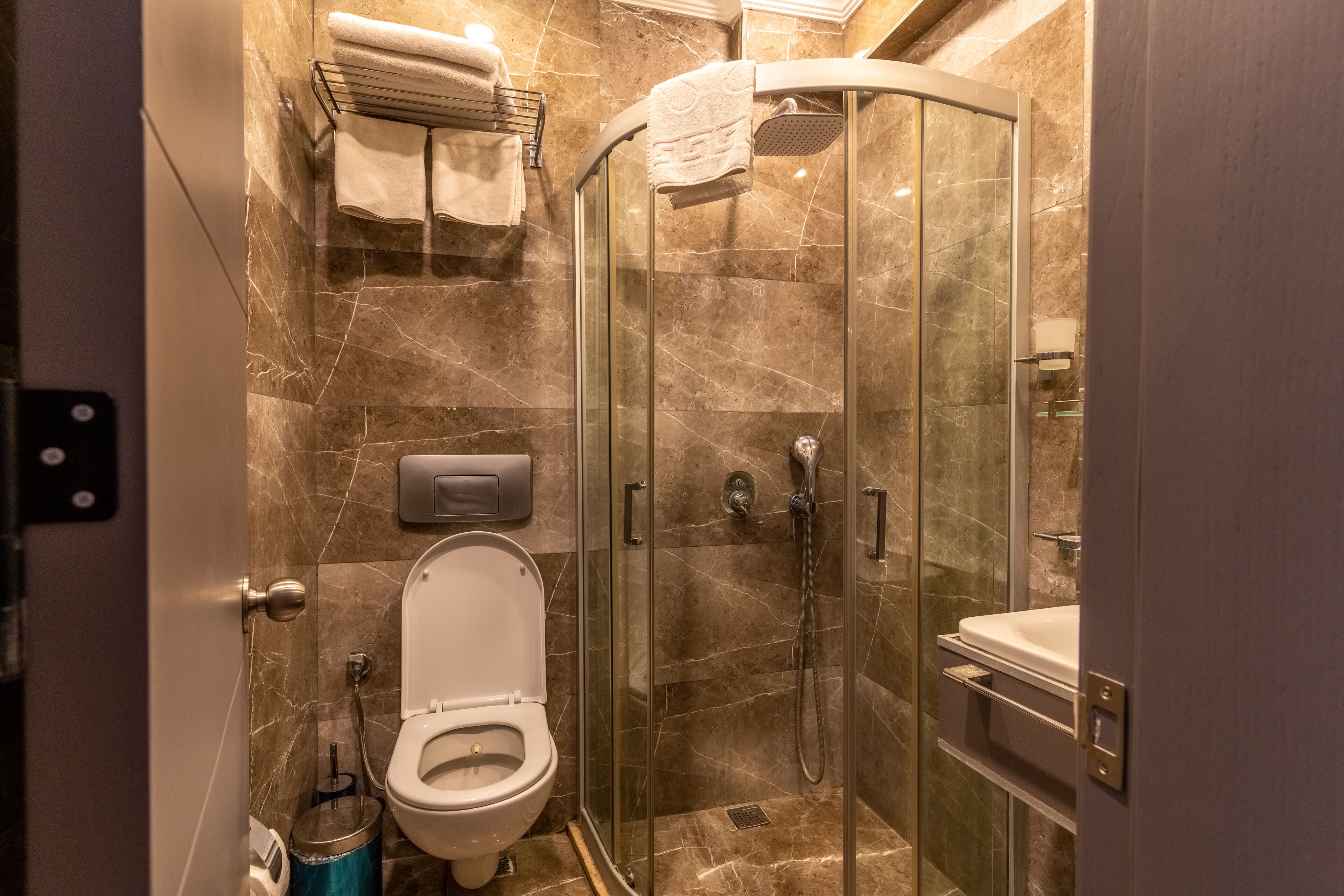 Une salle de bain moderne avec une douche à parois de verre, des toilettes et un lavabo.
