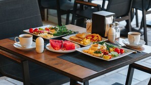 A dining table with plates of food, cups, and condiments. - Akkan Hotel (Bodrum)