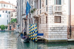 A canal scene with a gondola, buildings, and a flag. - Hotel Ai Cavalieri di Venezia (Venice)