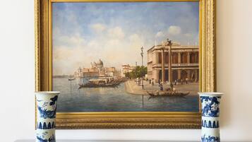 A framed painting of a canal scene with gondolas, buildings, and people.