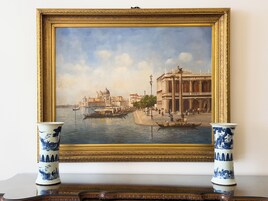 Un quadro incorniciato raffigura una scena di un canale con gondole, edifici e persone.