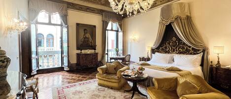 Une chambre luxueuse dotée d’un grand lit, d’un lustre somptueux et d’un décor classique.