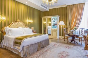 Un'elegante camera da letto con un letto grande, un armadio, una toeletta e un lampadario.