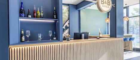 Un área de bar moderna con una decoración azul, una barra de madera y una variedad de botellas y vasos.