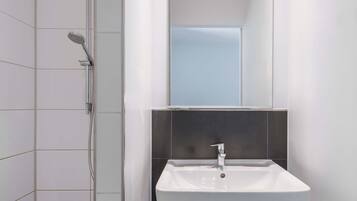 Ein modernes Badezimmer mit Dusche, Waschbecken und Spiegel.