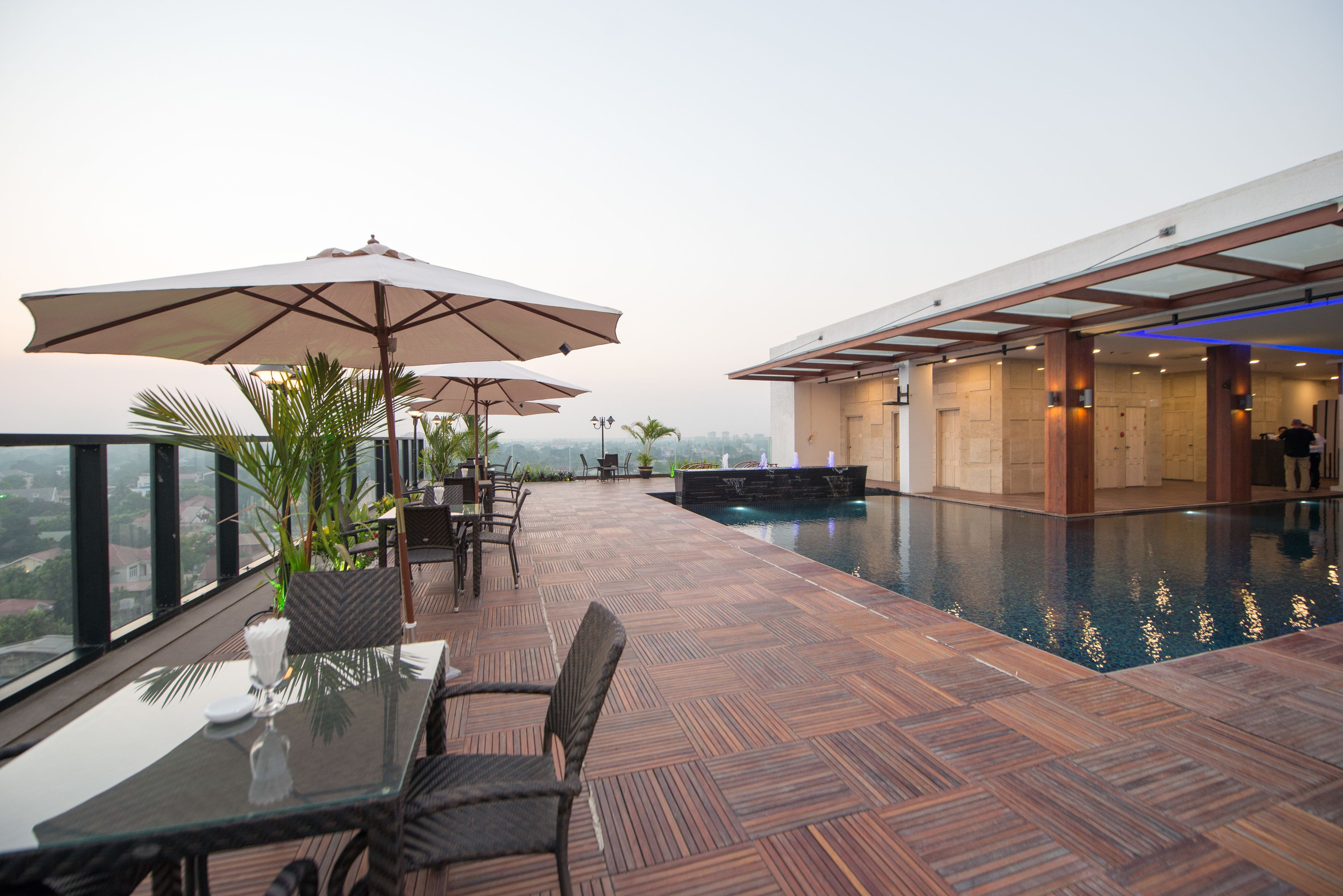 A rooftop terrace with a pool, dining area, and lounge chairs.