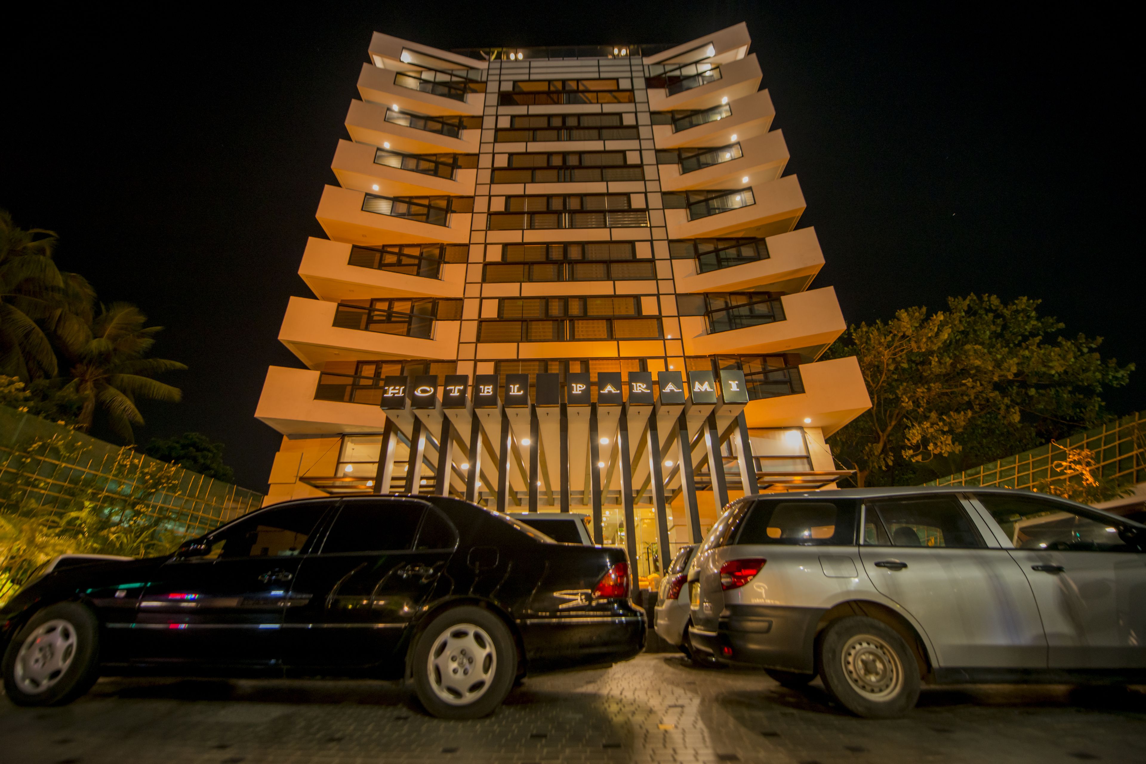 A multi-story hotel with a modern design, featuring a prominent entrance with a sign.