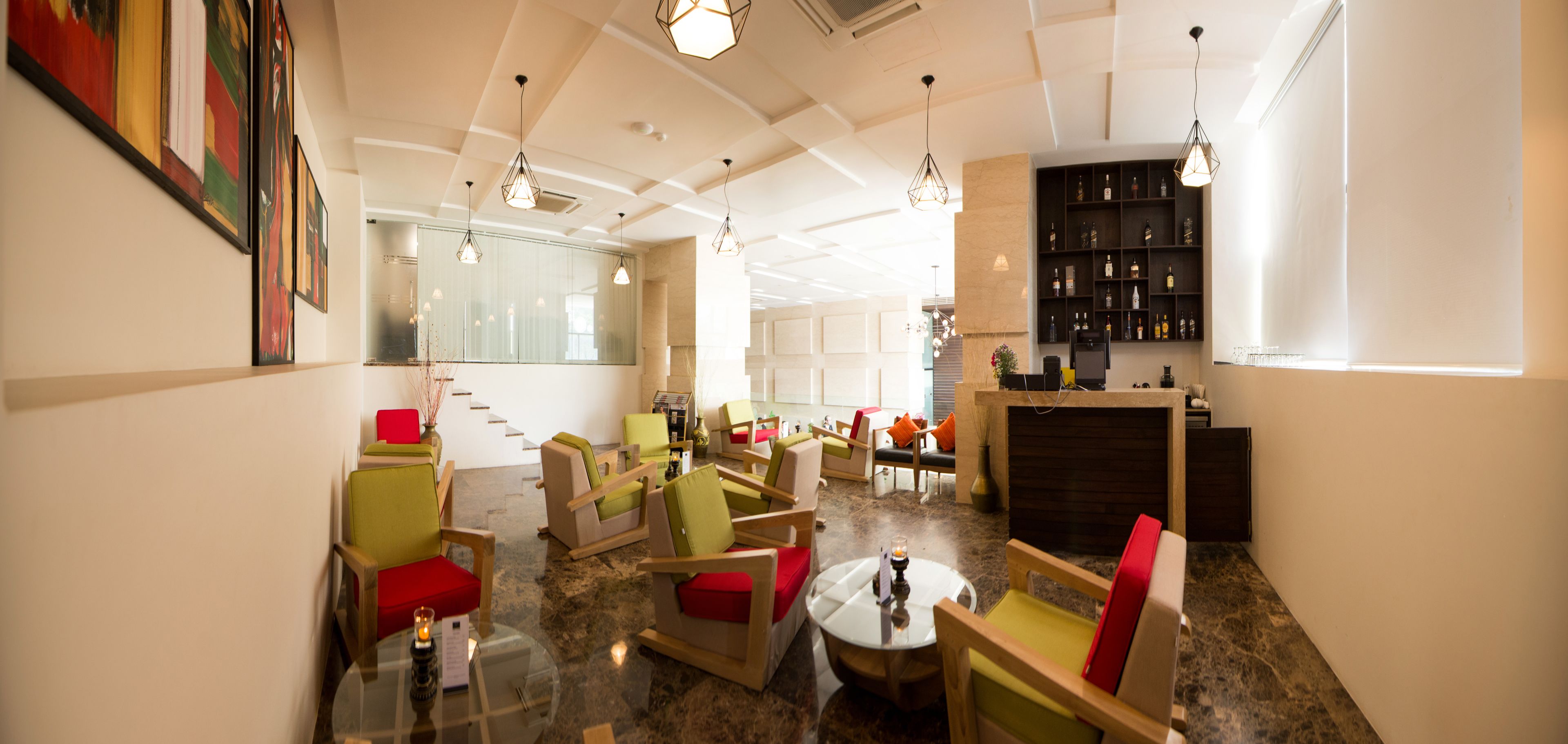 A modern lounge area with multiple seating options, a fireplace, and a bar area with shelves of bottles.