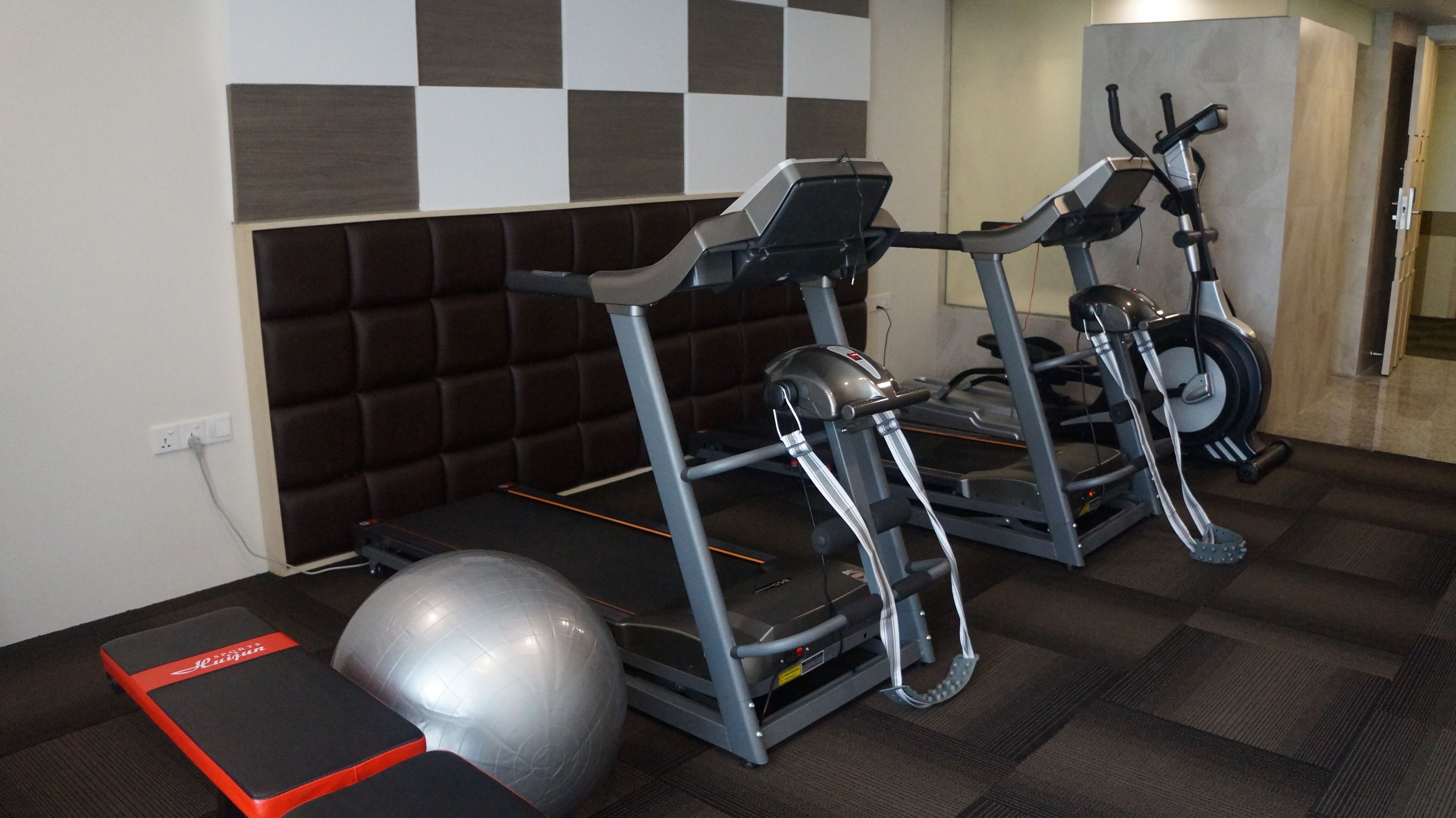 Ett gym med löpband och en träningsboll.
