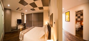 A modern hotel room with a large bed, a flat-screen TV, a desk, and a wardrobe. - Hotel Parami (Yangon)