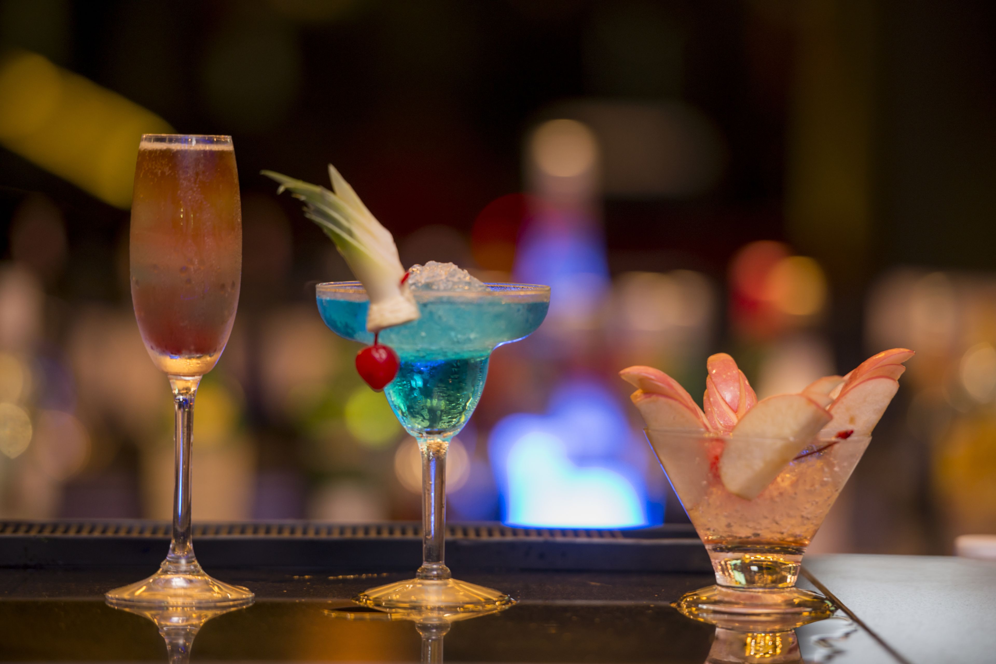 Three cocktails on a bar counter.