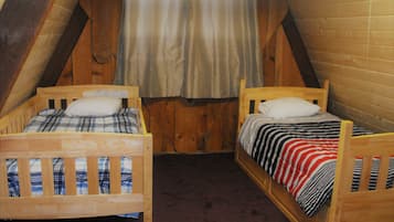 Due letti a castello in legno in una stanza con soffitto spiovente e pareti di legno.
