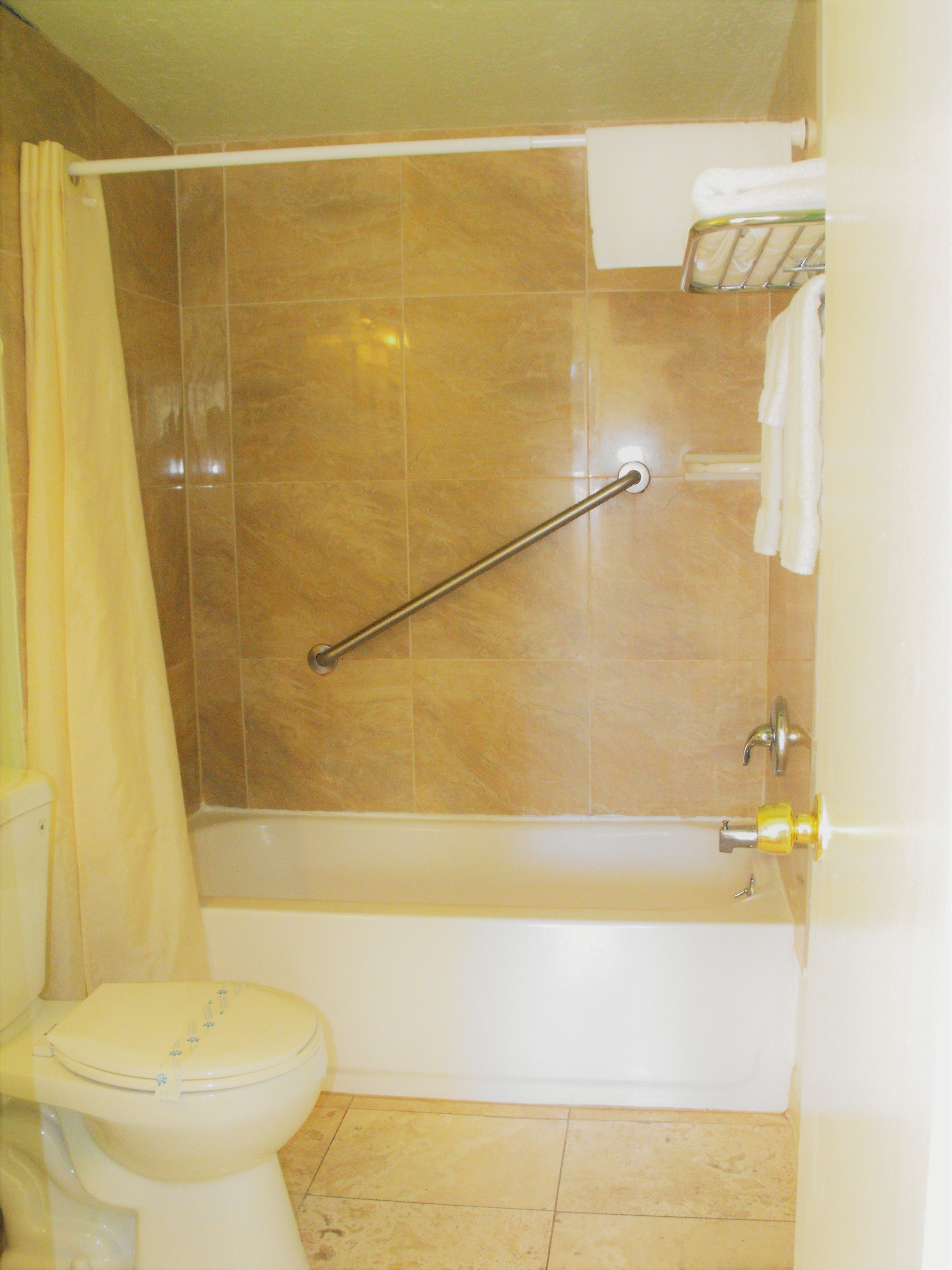 A bathroom with a bathtub, toilet, and shower curtain.