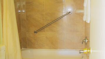 A bathroom with a bathtub, toilet, and shower curtain.