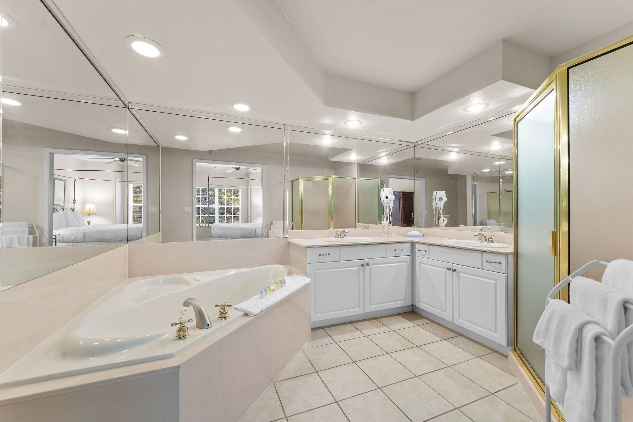A modern bathroom with a large bathtub, a double sink vanity, and a walk-in shower.