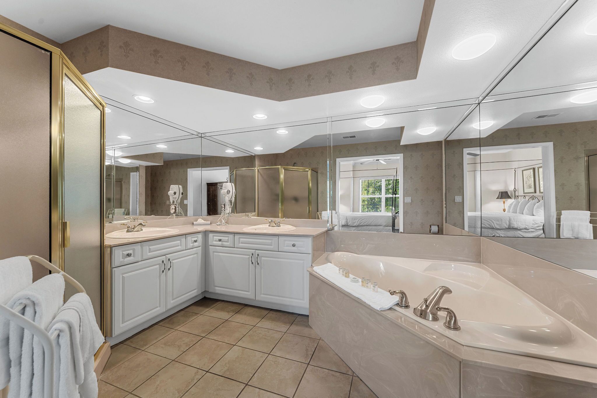 A modern bathroom with a large bathtub, double sinks, and a walk-in shower.