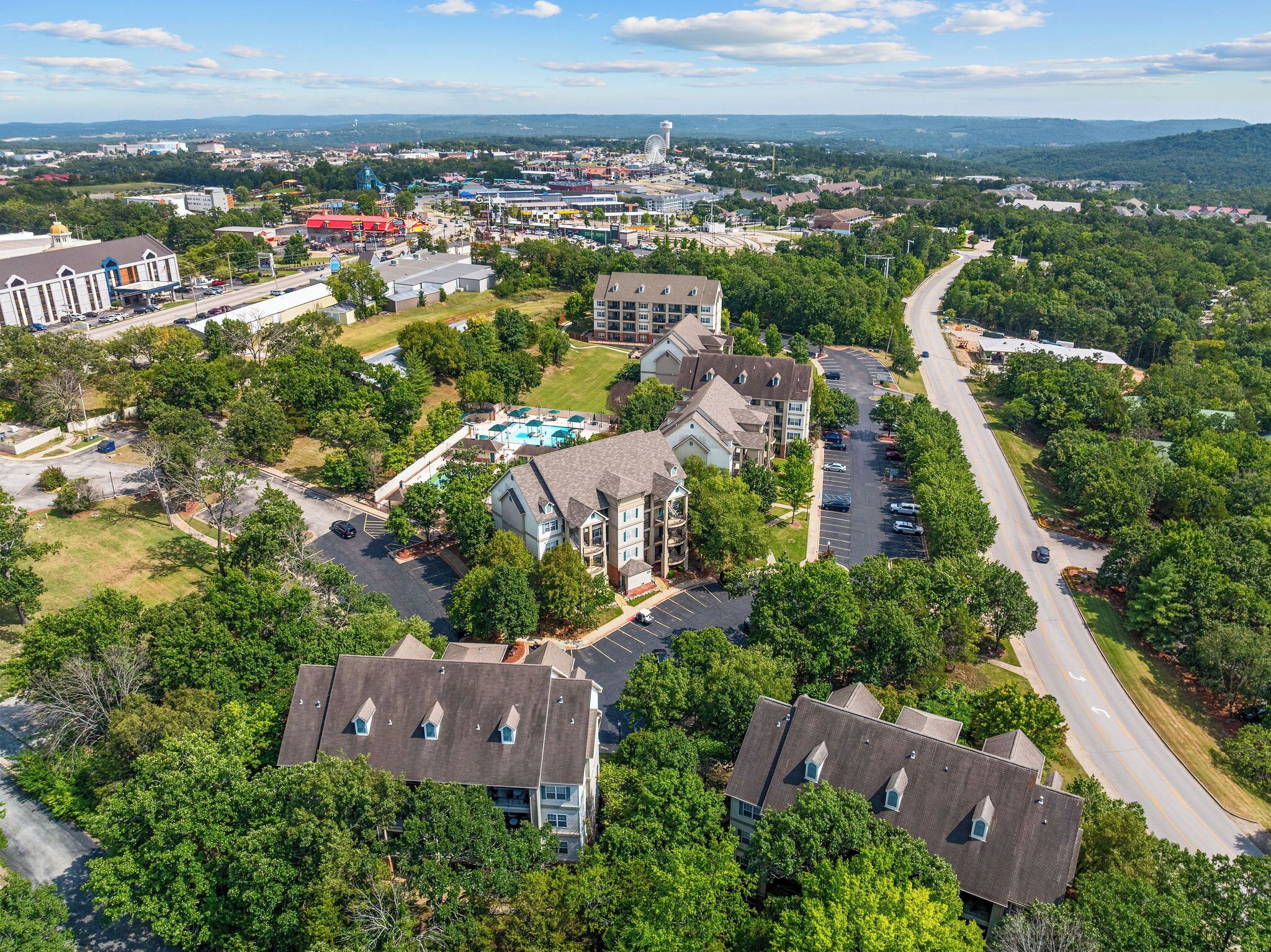 Vue aérienne d’un quartier résidentiel avec des maisons, une piscine et une route.