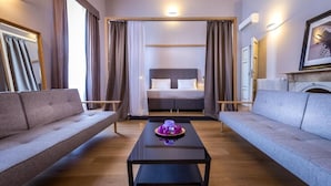 A modern hotel room with a large bed, two sofas, a coffee table, and a fireplace. - Residenza D'Epoca Al Numero 8 (Florence)