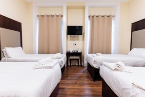 Habitación cuádruple, baño privado | Escritorio, tabla de planchar con plancha, wifi gratis y ropa de cama