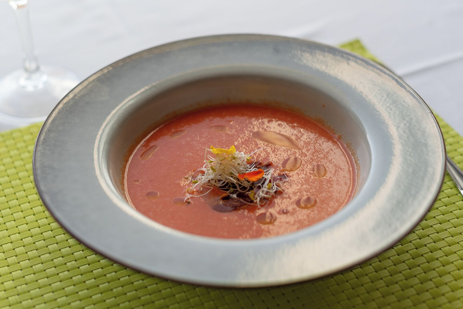 Uma tigela de sopa com um enfeite sobre um tapete de palha.
