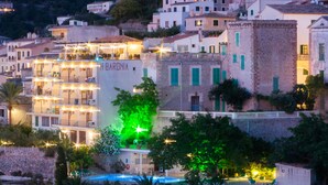 Un hotel con varios balcones, piscina y vistas de los edificios circundantes.