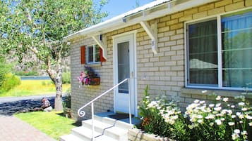 A single-story house with a brick facade, a front door, and a small porch with steps leading to the door.