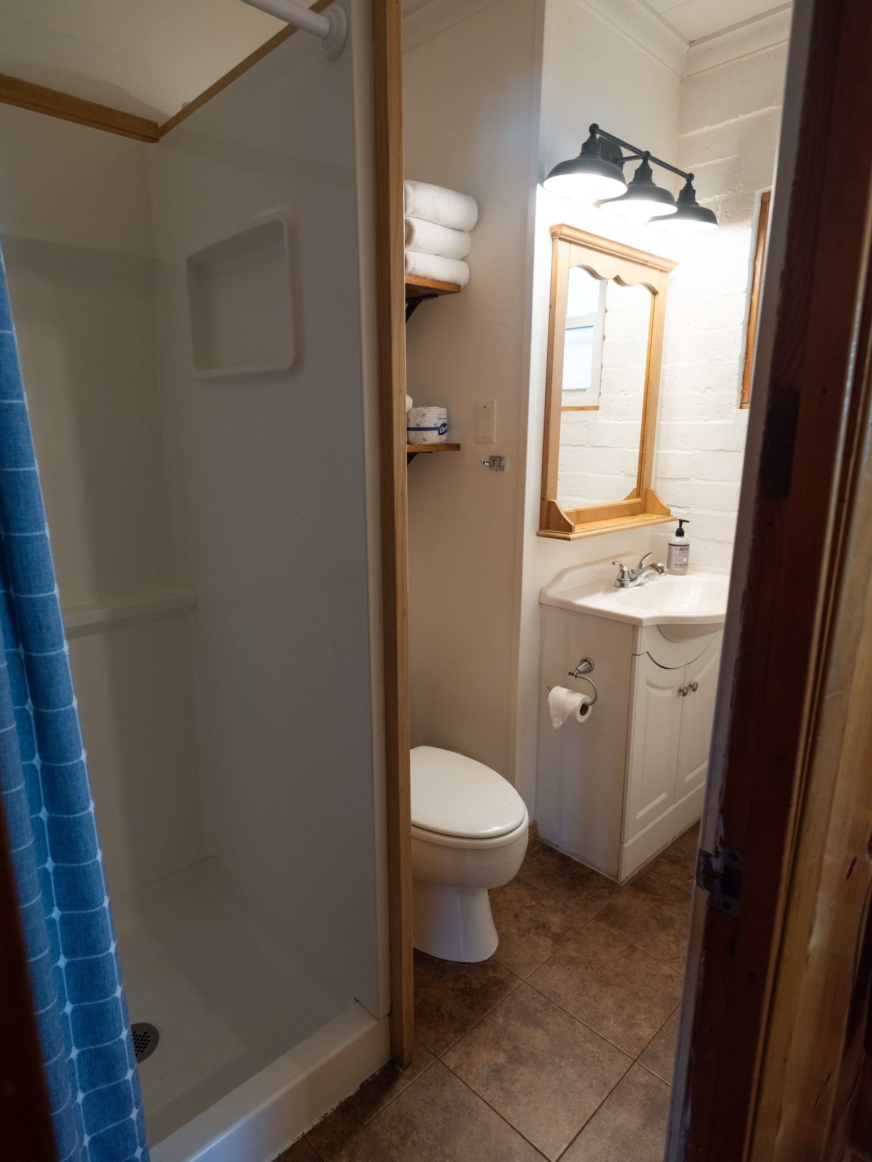 A bathroom with a shower, toilet, and sink.