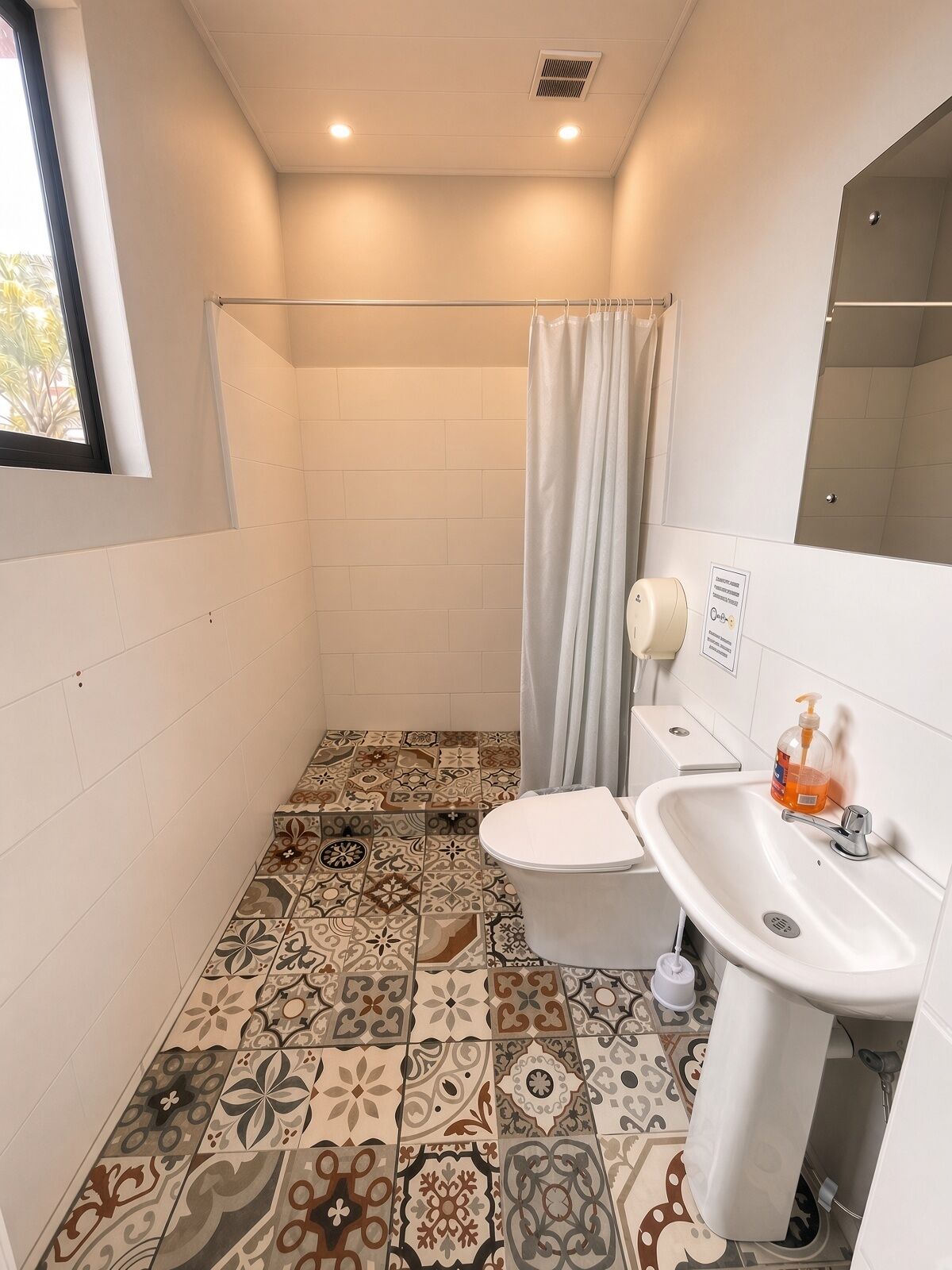Un baño con inodoro, lavamanos y cortina de ducha.