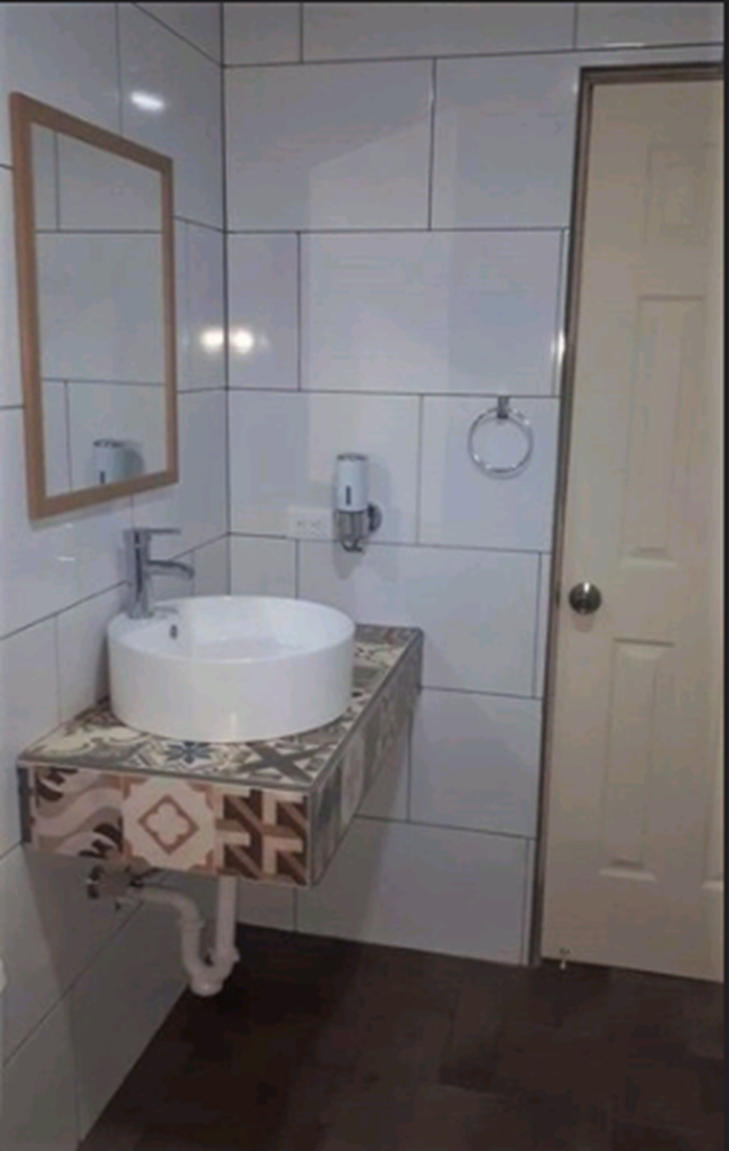 Un baño con un lavabo blanco, un espejo y un inodoro.