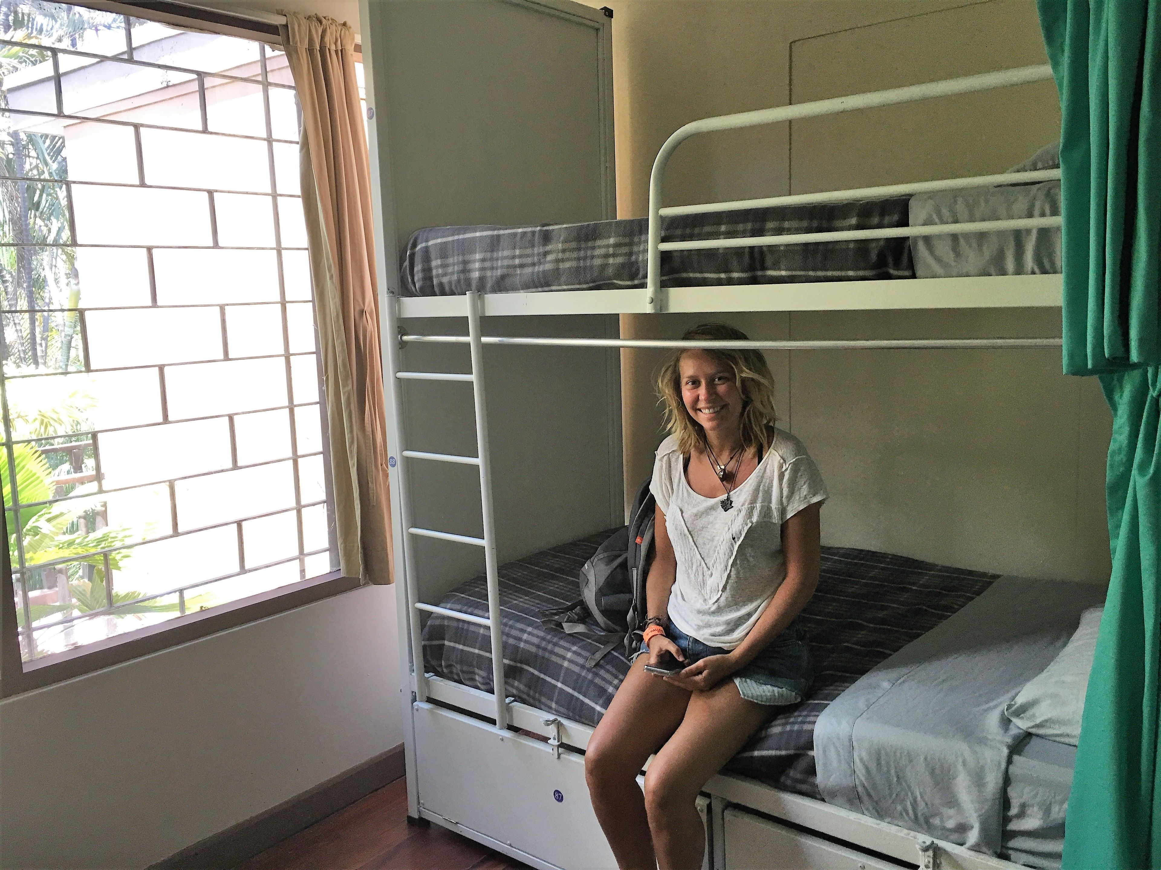 A bunk bed room with a window and curtains.