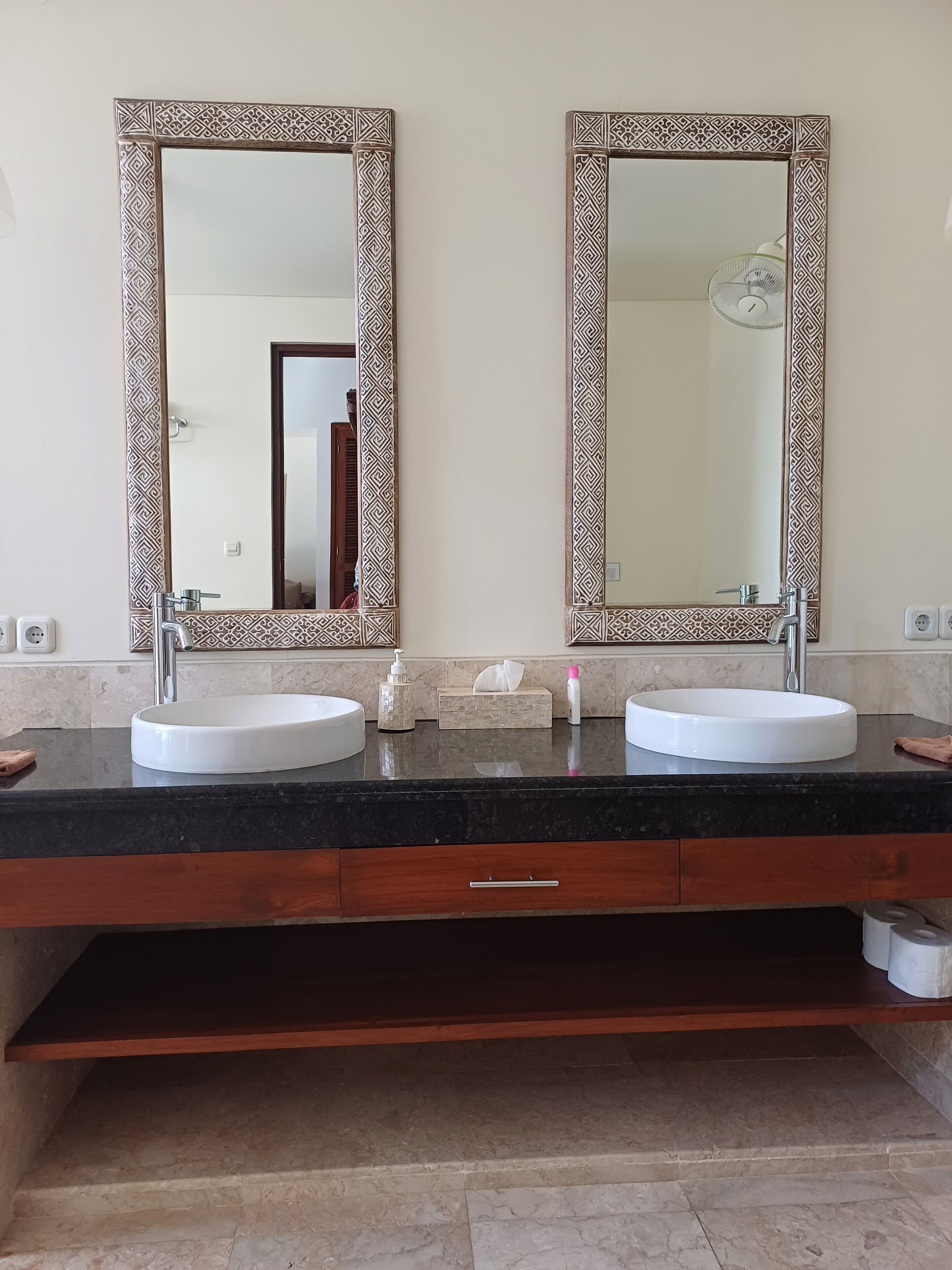 Une salle de bain avec deux lavabos, un miroir et un porte-serviettes.