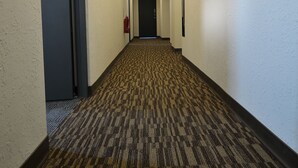 A hotel hallway with carpeted floors, white walls, and recessed lighting. - Century Hotel (Kaohsiung)