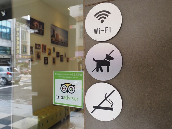 A wall with three circular signs: Wi-Fi, dog, and no smoking. - Century Hotel (Kaohsiung)
