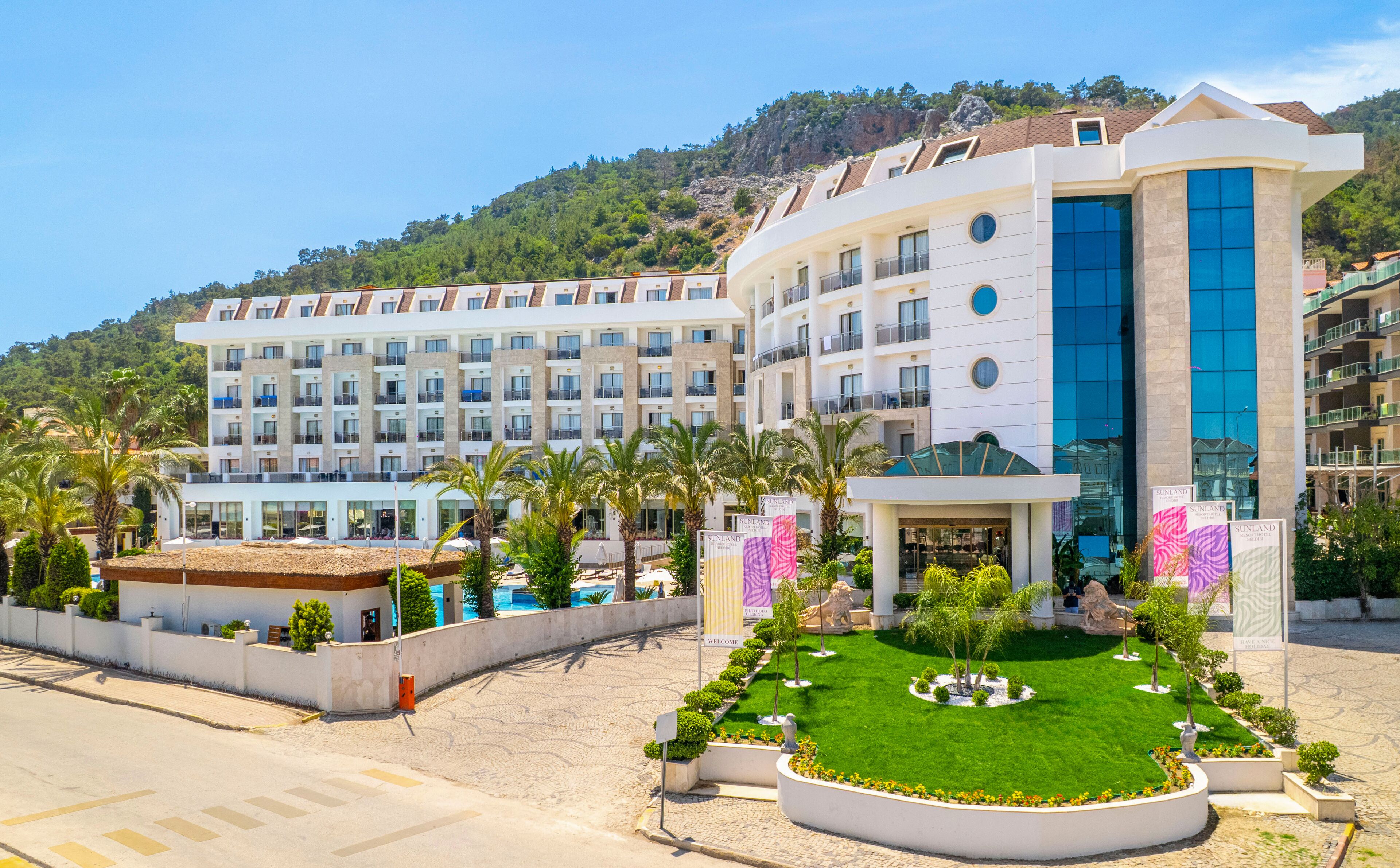 A hotel with multiple floors, a swimming pool, and a well-maintained garden.