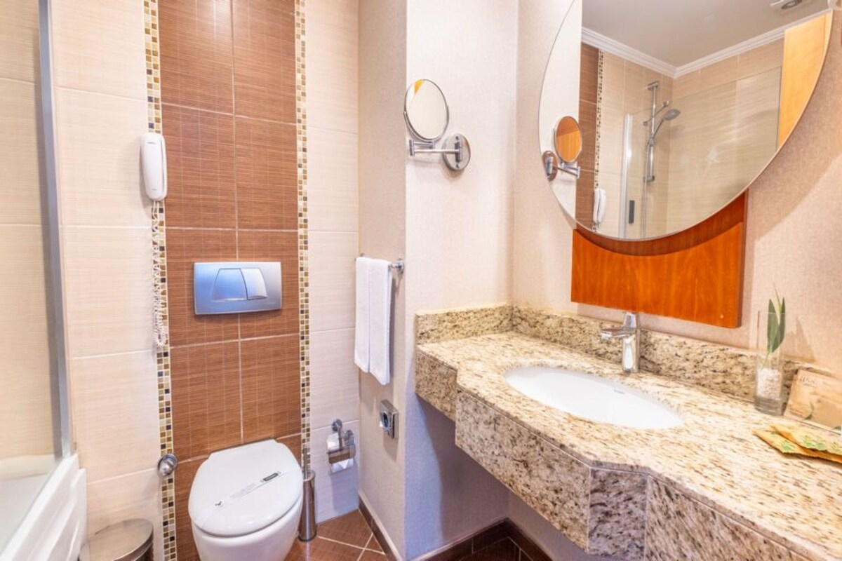 A bathroom with a toilet, sink, and shower.